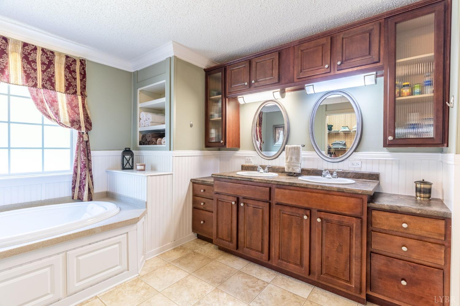 2570 Reedy Spring Road Spout Spring, VA 24593 - Photo 27 of 66 a spacious bathroom with a granite countertop double vanity sink a mirror and a bathtub