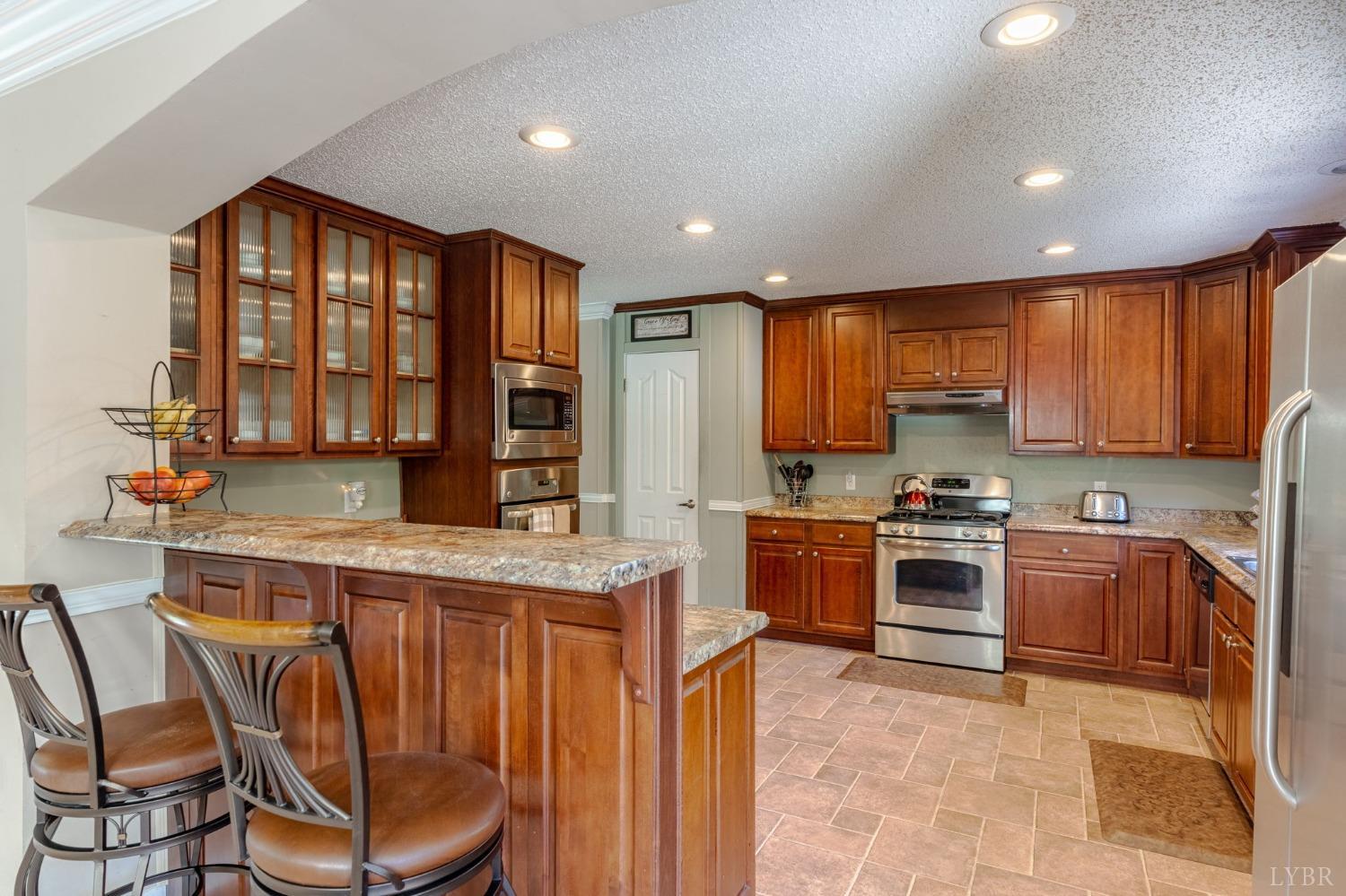 2570 Reedy Spring Road Spout Spring, VA 24593 - Photo 7 of 66 a kitchen with stainless steel appliances granite countertop wooden cabinets a stove top oven a granite counter top and a stove