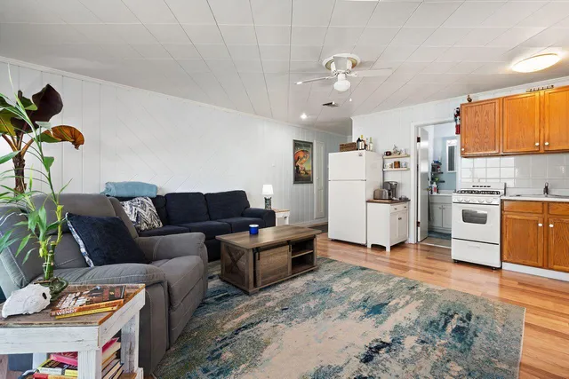 a living room with furniture a flat screen tv and a table