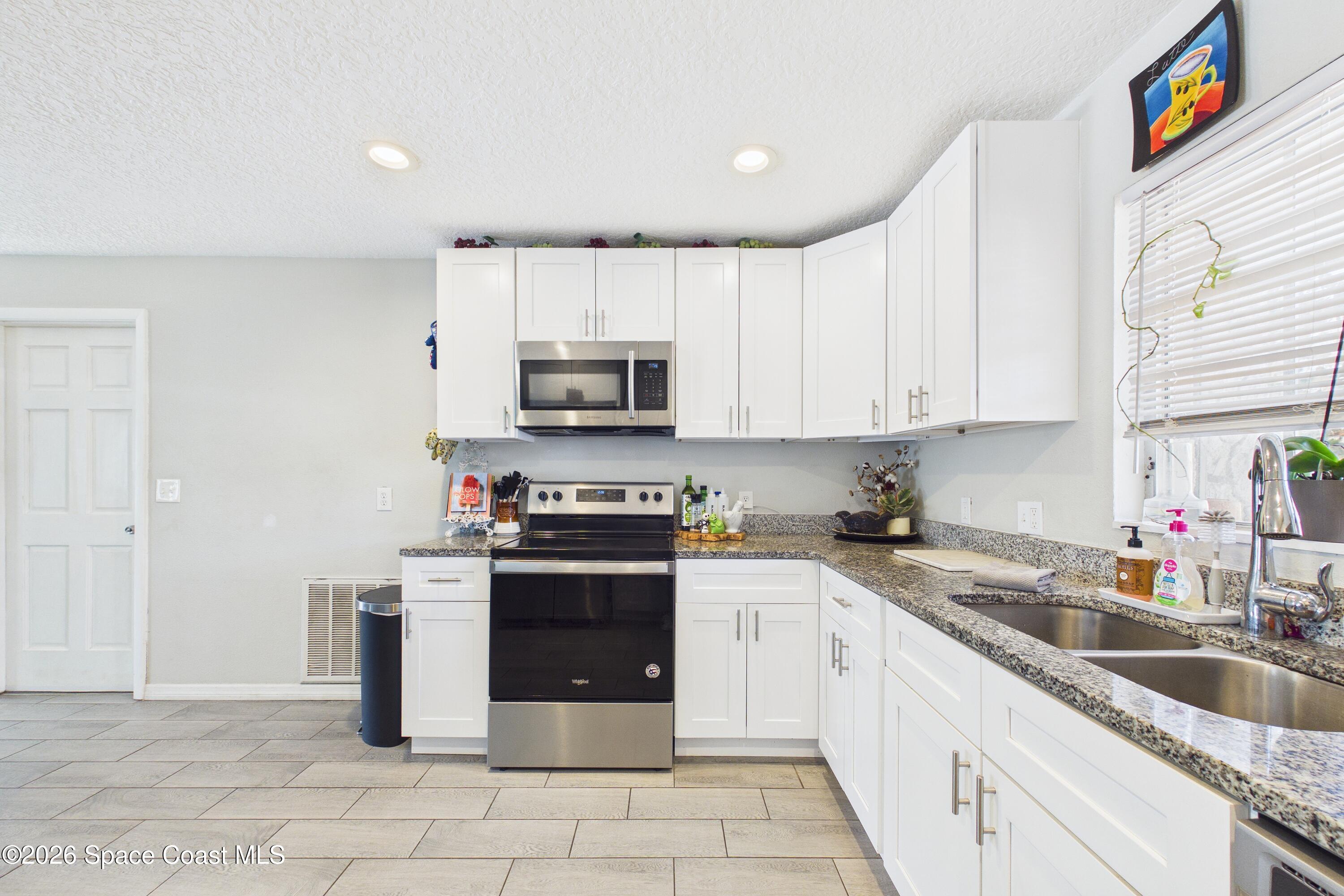 1300 Lester Court Merritt Island, FL 32952 - Photo 22 of 50 a kitchen with stainless steel appliances granite countertop a sink and cabinets
