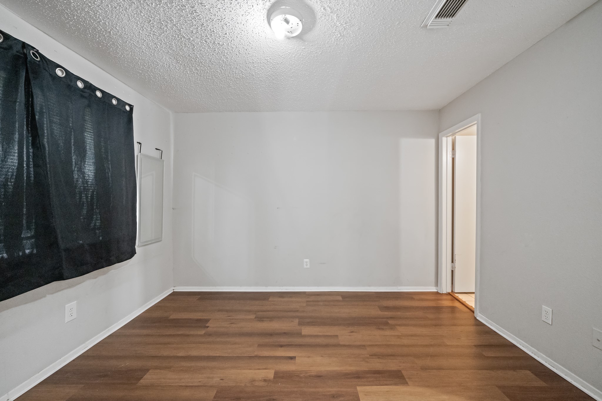 20115 Raingate Lane Katy, TX 77449 - Photo 19 of 25 a view of an empty room with wooden floor and a window