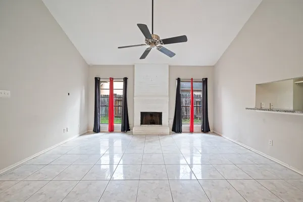a view of an empty room with window and fireplace