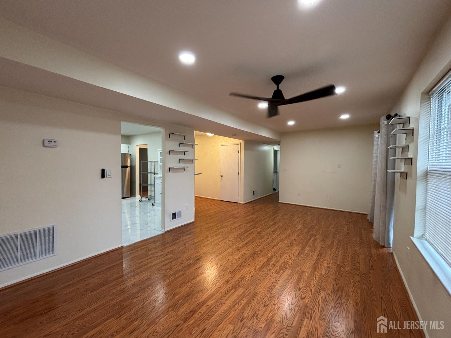 1301 Plymouth Road North Brunswick, NJ 08902 - Photo 2 of 21 a view of a kitchen with wooden floor and a ceiling fan