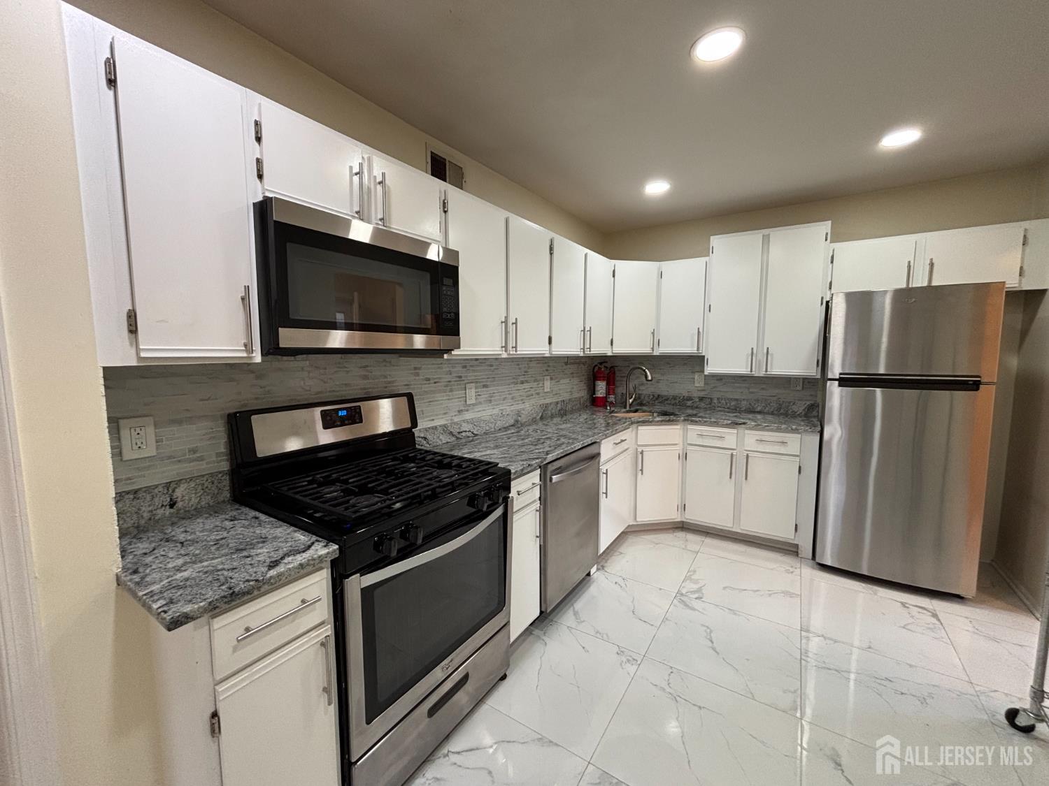 1301 Plymouth Road North Brunswick, NJ 08902 - Photo 4 of 21 a kitchen with granite countertop a stove sink and refrigerator