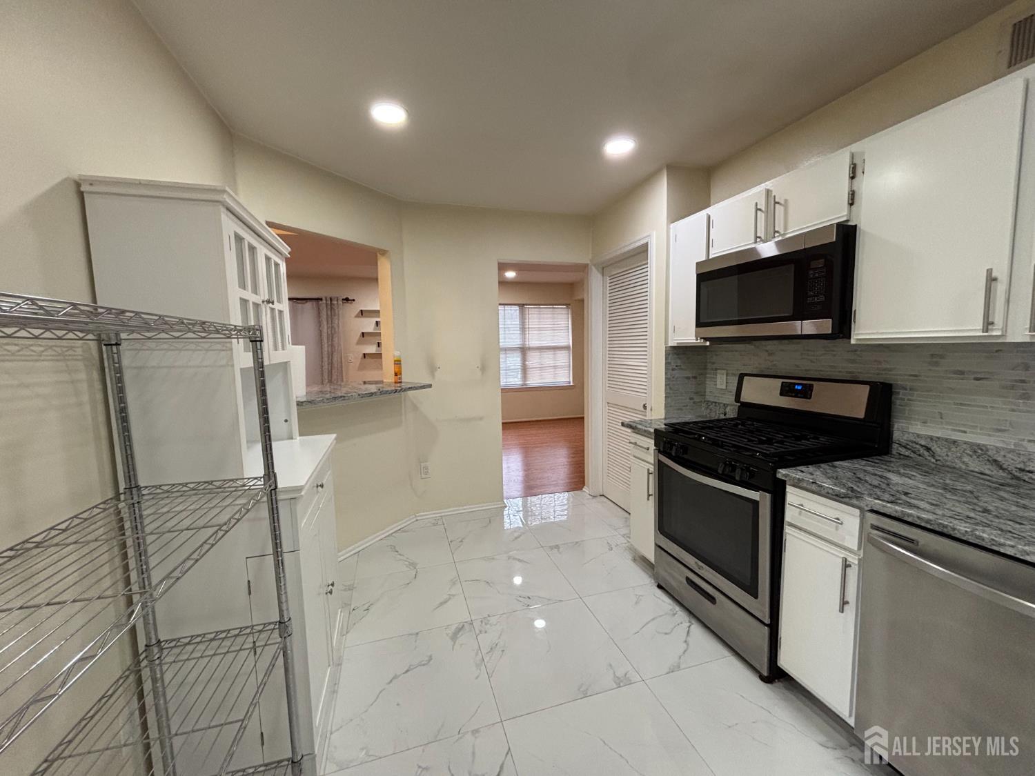 1301 Plymouth Road North Brunswick, NJ 08902 - Photo 6 of 21 a kitchen with granite countertop a stove and a microwave