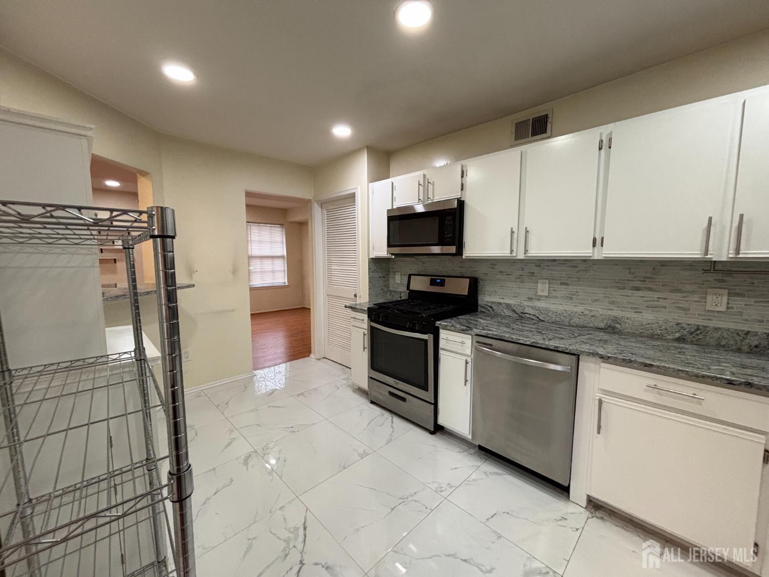 1301 Plymouth Road North Brunswick, NJ 08902 - Photo 8 of 21 a kitchen with stainless steel appliances granite countertop a stove a sink and a refrigerator