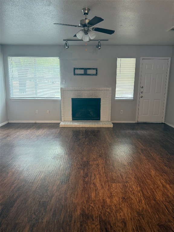 1802 River Crossing Circle, Unit C Austin, TX 78741 - Photo 7 of 19 an empty room with wooden floor fireplace and windows