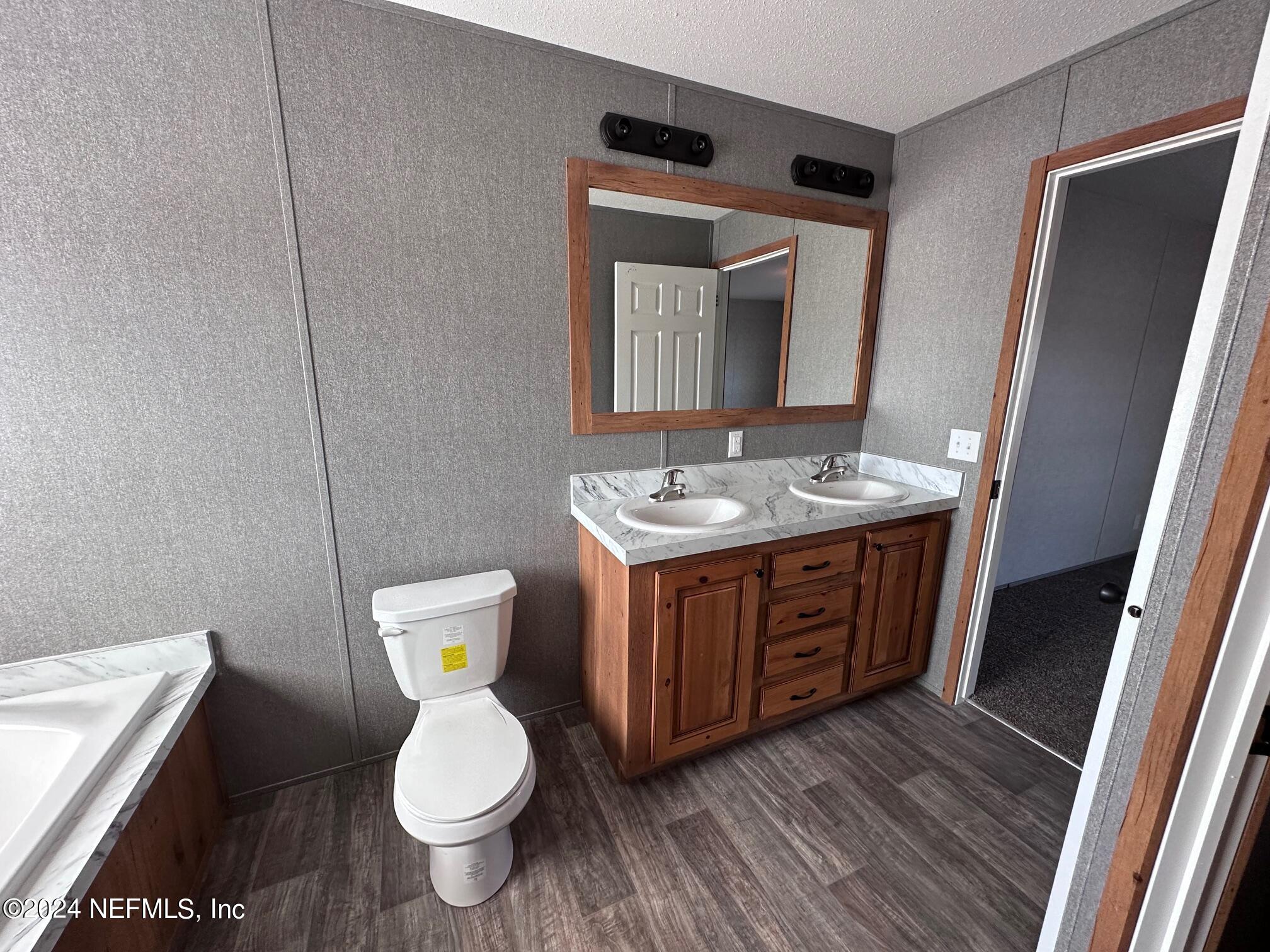 8682 Noah Davis Road Glen St. Mary, FL 32040 - Photo 15 of 19 a bathroom with a granite countertop toilet sink and mirror
