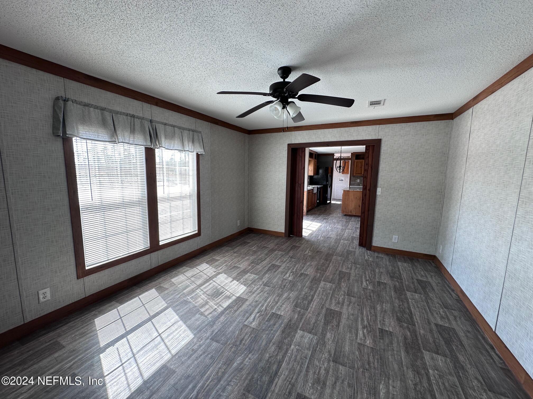 8682 Noah Davis Road Glen St. Mary, FL 32040 - Photo 5 of 19 a view of empty room with wooden floor and fan