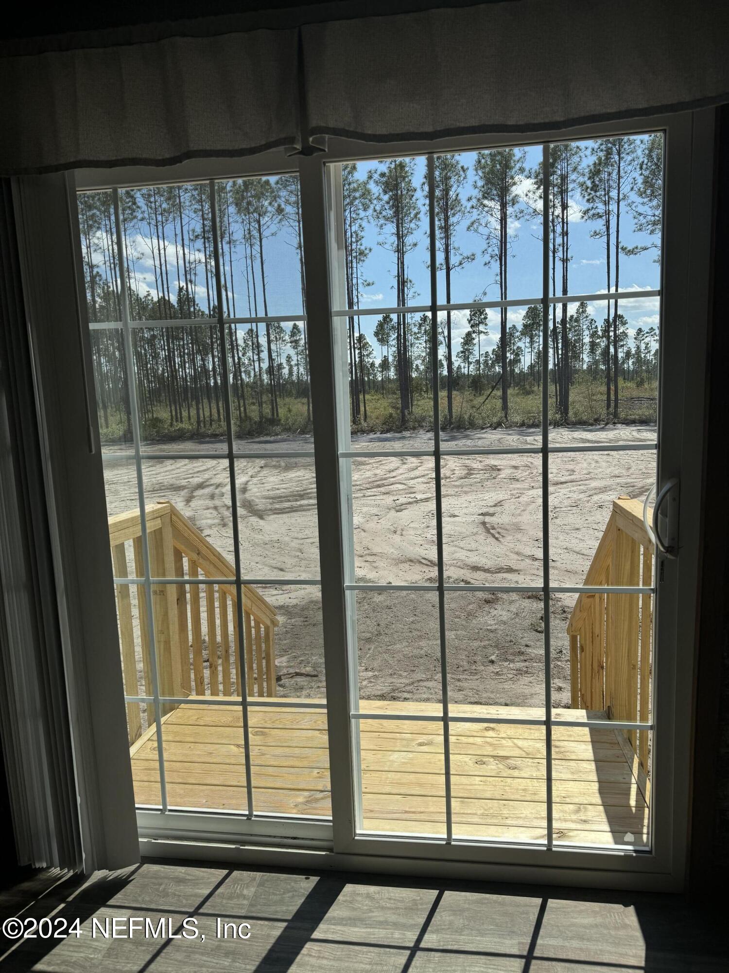 8682 Noah Davis Road Glen St. Mary, FL 32040 - Photo 9 of 19 a view of a glass door with a floor to ceiling window