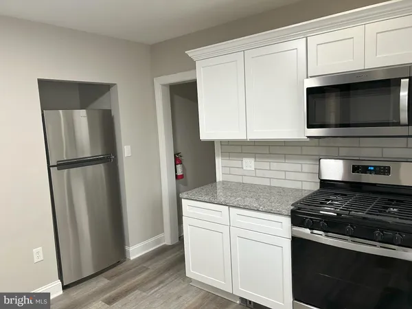 a kitchen with white cabinets and stainless steel appliances