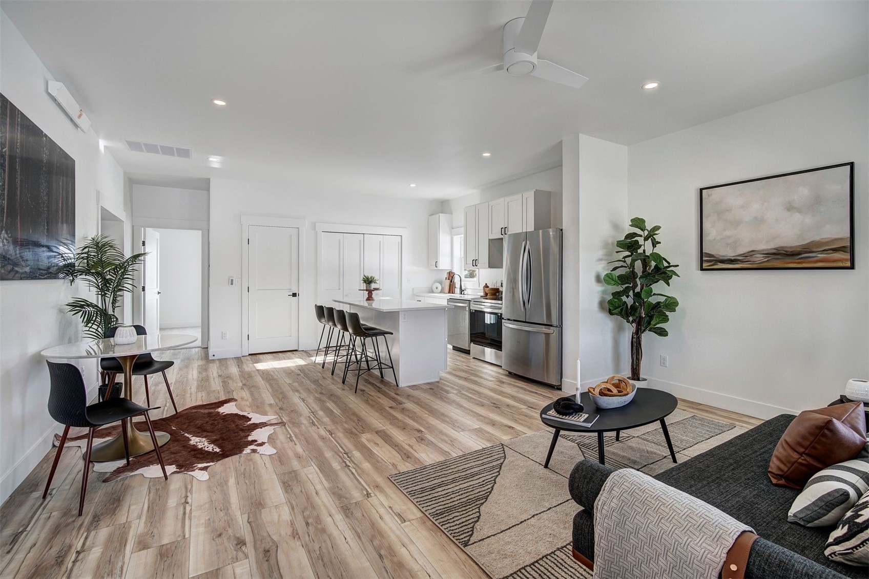 a living room with furniture and a dining table with kitchen view