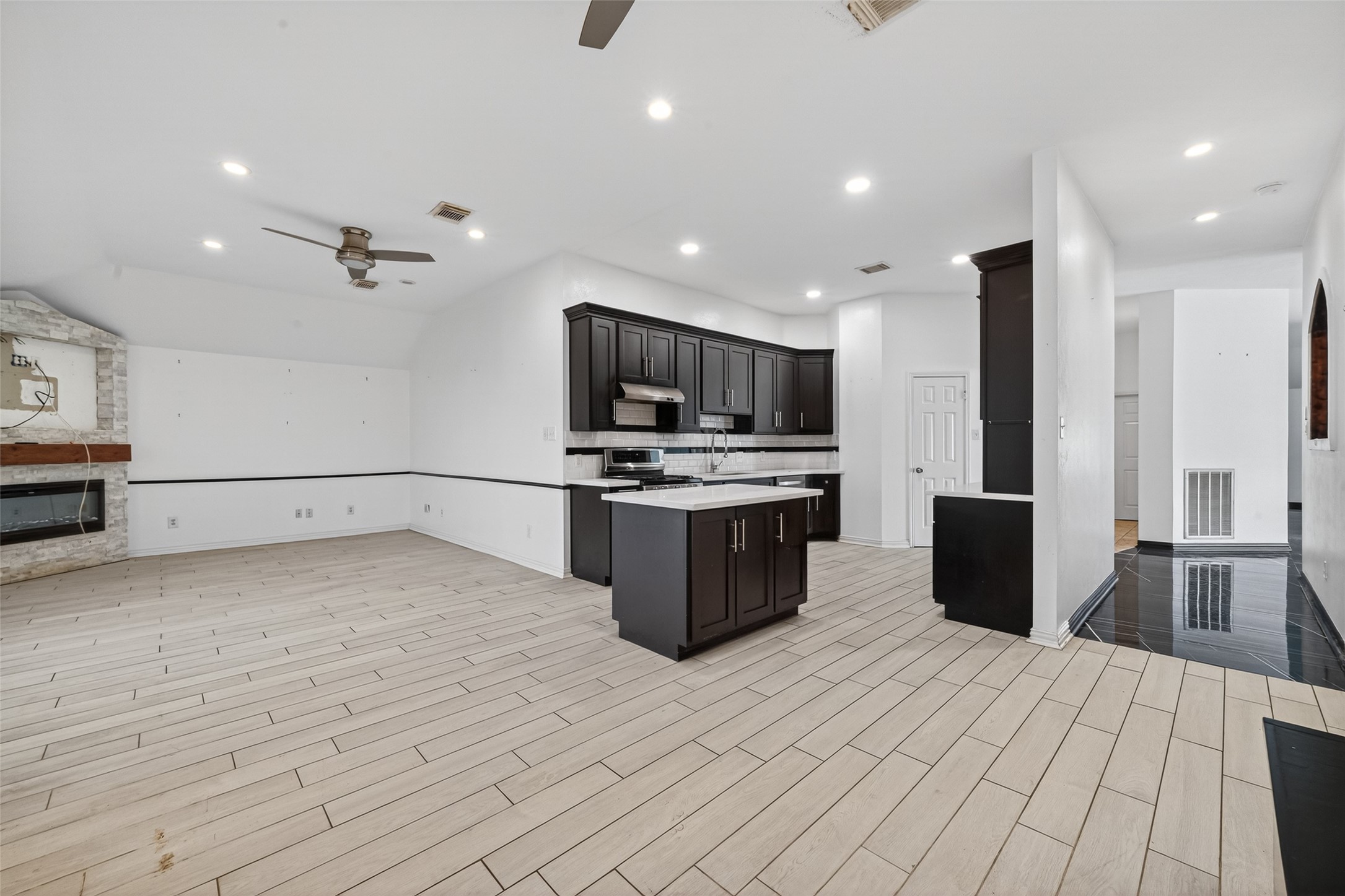 2214 Ruffian Lane Stafford, TX 77477 - Photo 14 of 31 a kitchen with stainless steel appliances a stove top oven a sink dishwasher a refrigerator and a dining table with wooden floor
