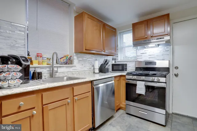 a stove top oven sitting inside of a kitchen
