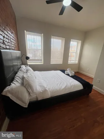 a bedroom with a bed and a ceiling fan