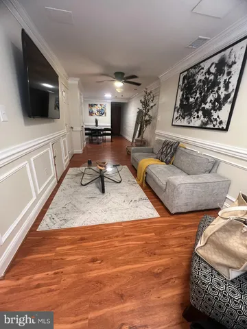 a living room with furniture a rug and a wall painting