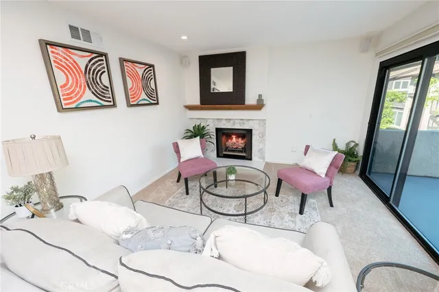 a living room with furniture a fireplace and wall paintings
