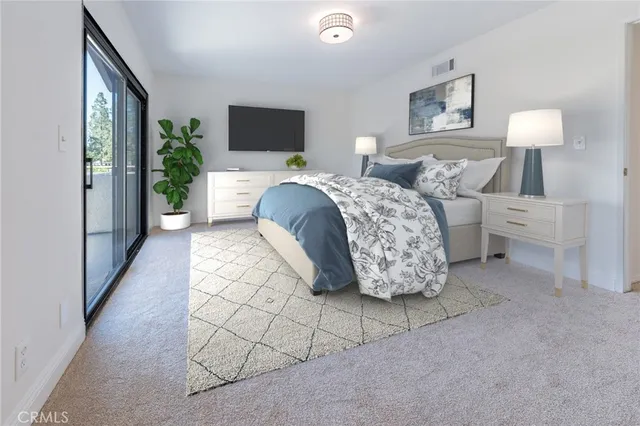 a spacious bedroom with a bed and a flat screen tv