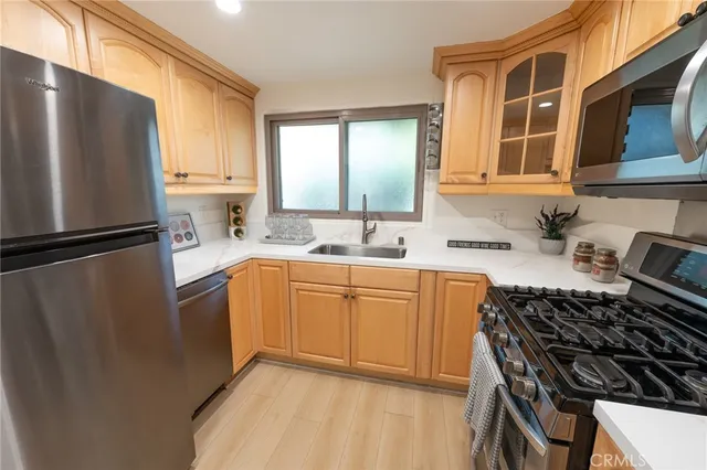 a kitchen with stainless steel appliances granite countertop a refrigerator and a sink