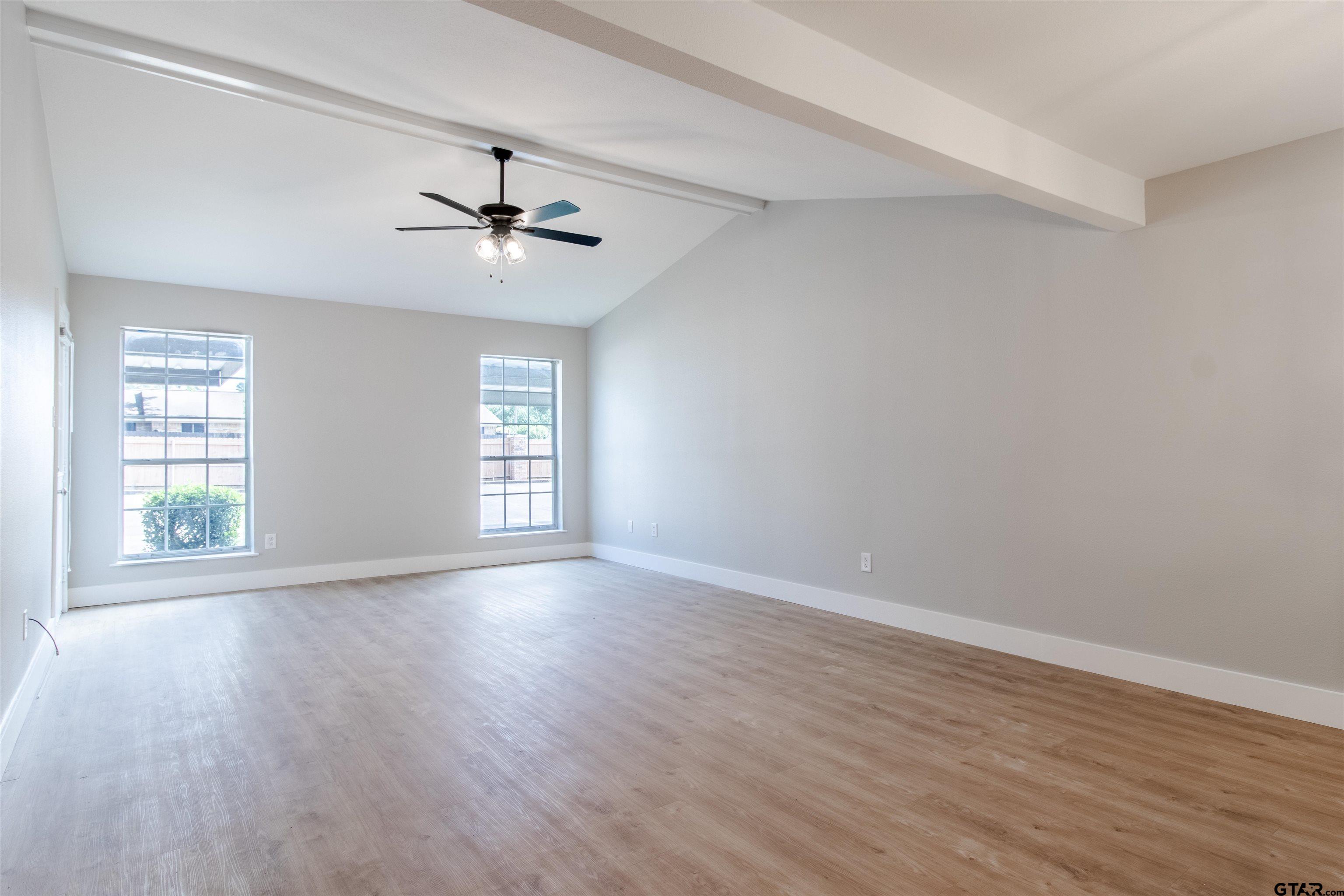 415 Thigpen Drive Tyler, TX 75703 - Photo 17 of 32 an empty room with wooden floor ceiling fan and windows