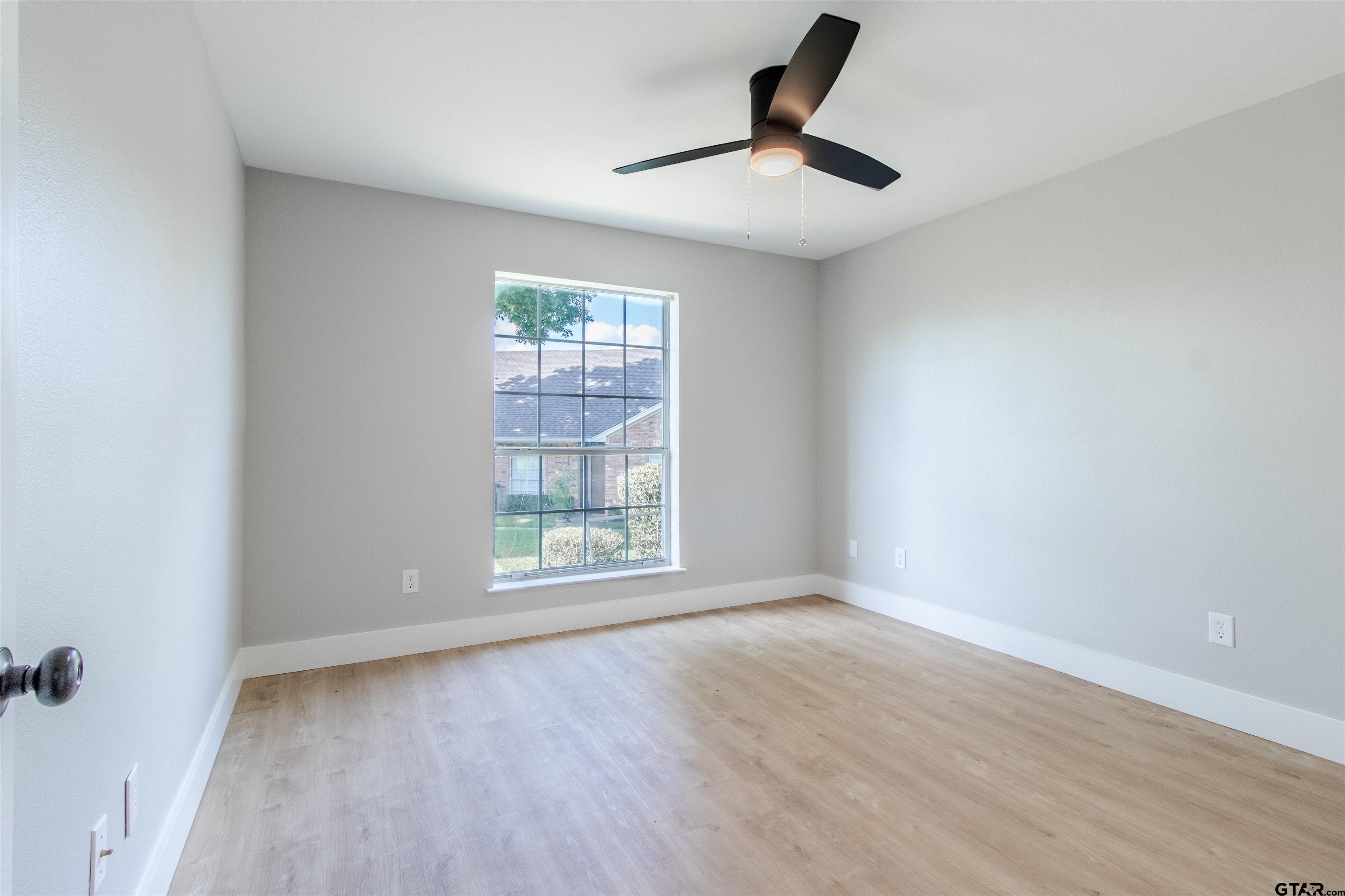 415 Thigpen Drive Tyler, TX 75703 - Photo 25 of 32 an empty room with wooden floor fan and windows
