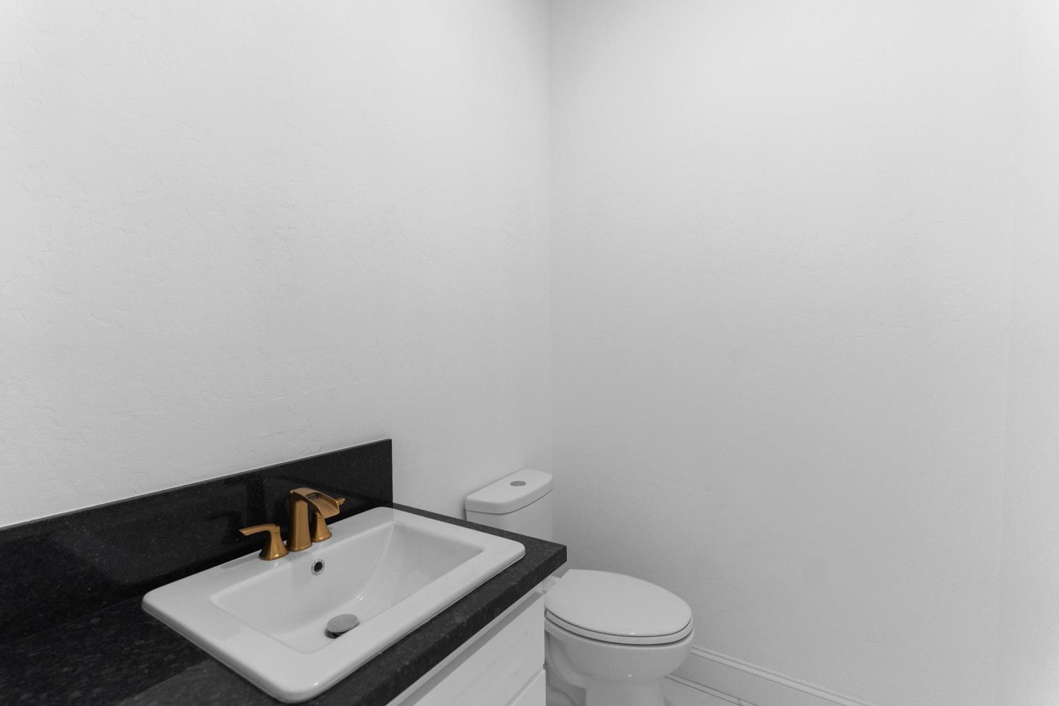 36950 Pauline Avenue Madera, CA 93636 - Photo 12 of 48 a white toilet sitting next to a bathroom sink