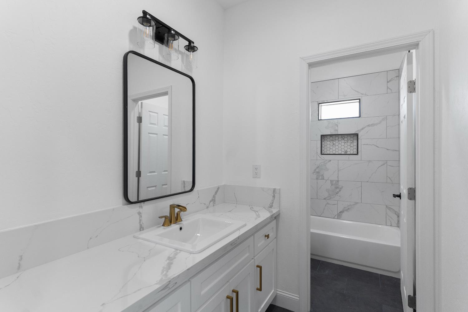 36950 Pauline Avenue Madera, CA 93636 - Photo 22 of 48 a bathroom with a bathtub sink vanity and mirror