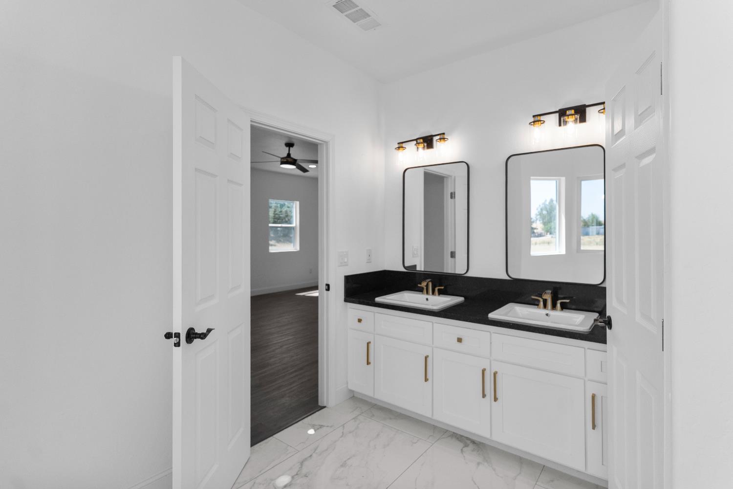 36950 Pauline Avenue Madera, CA 93636 - Photo 23 of 48 a bathroom with a granite countertop sink and a mirror