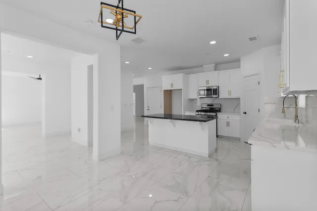 a kitchen with stainless steel appliances granite countertop a refrigerator and a sink