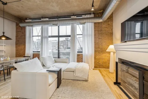 a living room with furniture large windows and a fireplace