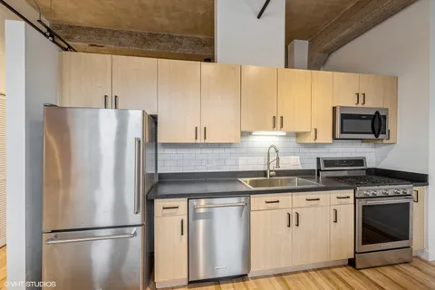 a kitchen with stainless steel appliances granite countertop a refrigerator sink and cabinets