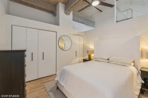 a bedroom with a large bed and wooden floor