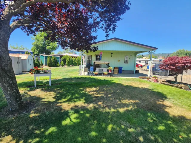 a view of backyard with a table and chairs and potted plants