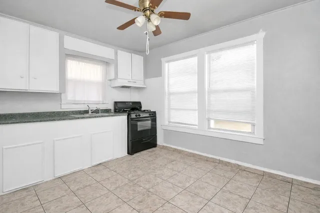 a kitchen with granite countertop a stove sink and microwave