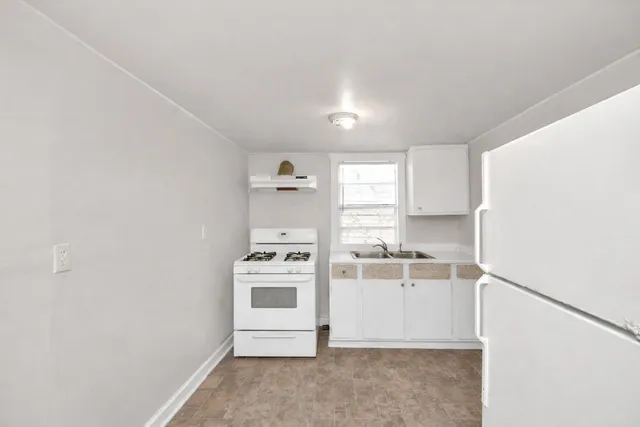 a kitchen with a stove cabinets and a window