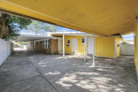 a view of a patio with table and chairs and wooden fence