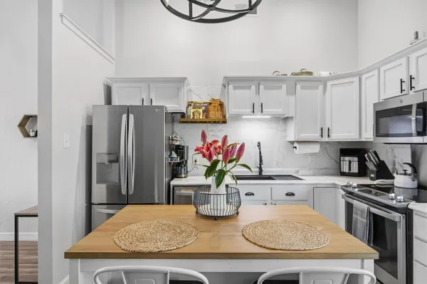 a kitchen with stainless steel appliances granite countertop a sink dishwasher and a refrigerator