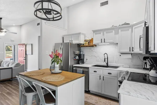 a kitchen with a table chairs and white cabinets