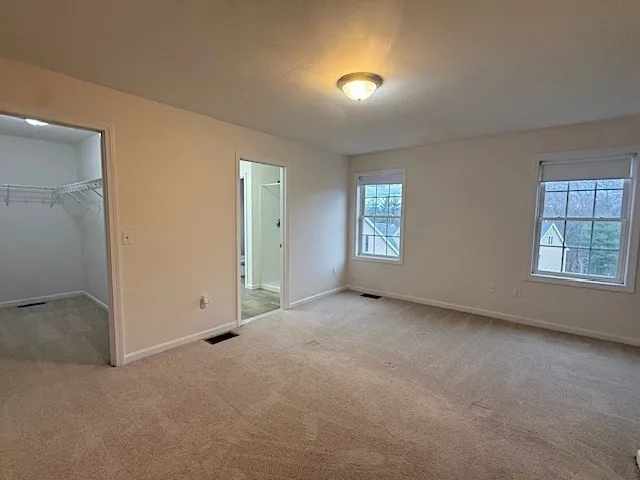 an empty room with windows and closet