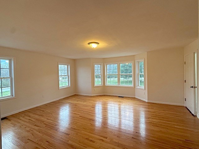 121 Robin Hill Road, Unit B Groton, MA 01450 - Photo 2 of 18 a view of empty room with wooden floor and fan