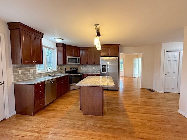 121 Robin Hill Road, Unit B Groton, MA 01450 - Photo 7 of 18 a kitchen with wooden floors and wooden cabinets
