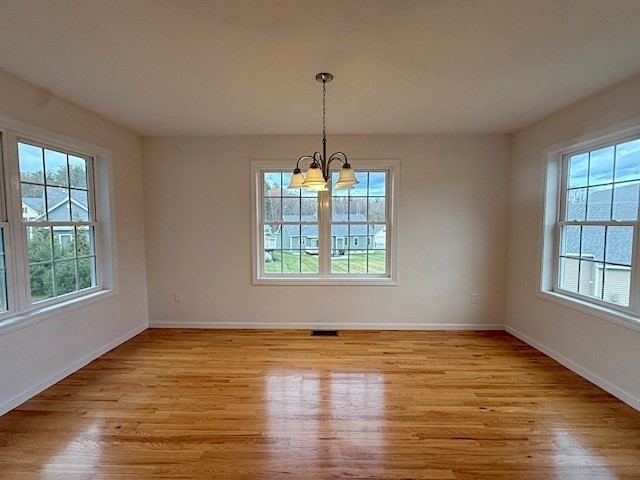 121 Robin Hill Road, Unit B Groton, MA 01450 - Photo 8 of 18 an empty room with wooden floor and windows