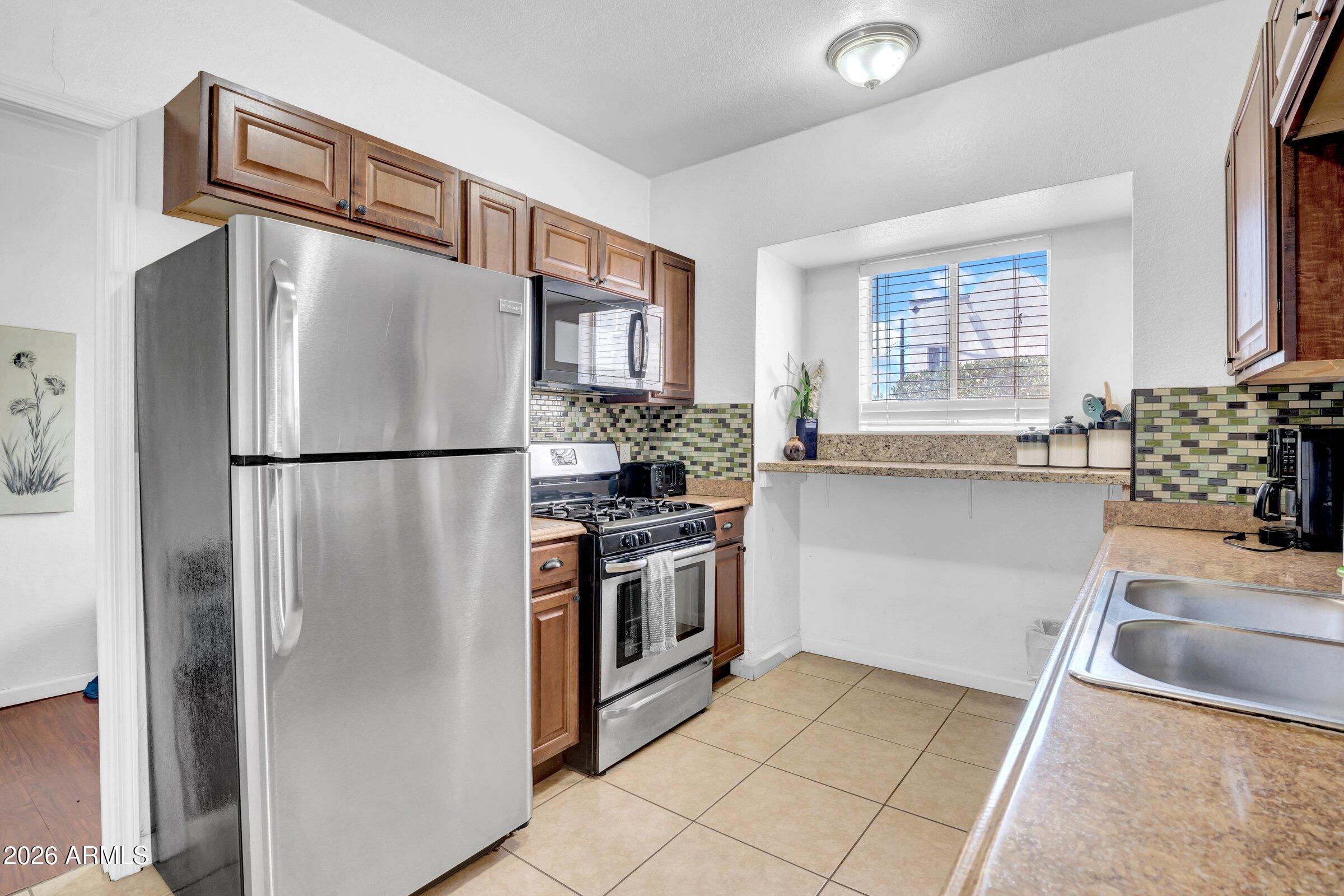 712 East Pierce Street Phoenix, AZ 85006 - Photo 9 of 39 a kitchen with stainless steel appliances granite countertop a refrigerator and a sink