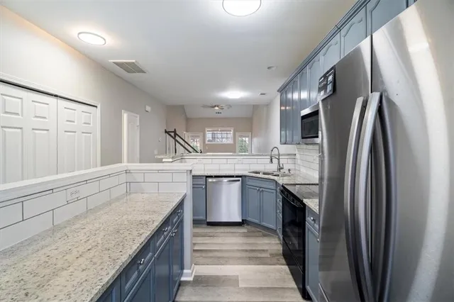 a kitchen with stainless steel appliances granite countertop a refrigerator a sink a stove and dishwasher