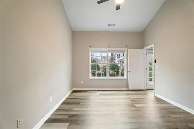 an empty room with wooden floor and windows