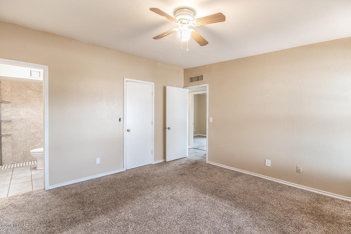 7761 North Rasmussen Avenue Tucson, AZ 85741 - Photo 9 of 23 an empty room with closet and a chandelier fan