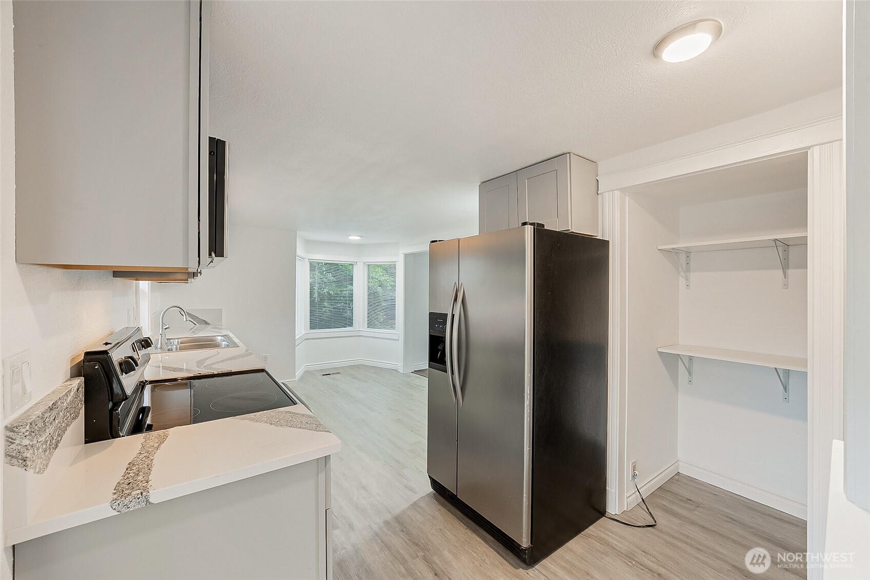 1607 Harrison Street Steilacoom, WA 98388 - Photo 13 of 37 a kitchen with stainless steel appliances granite countertop a refrigerator a stove and a sink with wooden floor