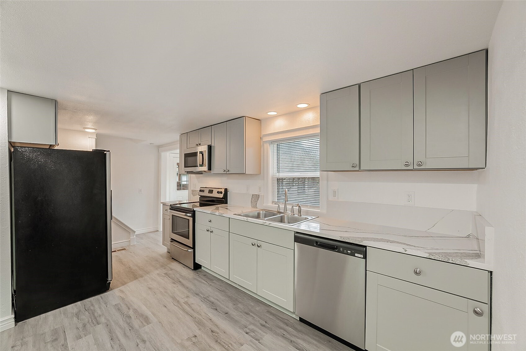 1607 Harrison Street Steilacoom, WA 98388 - Photo 10 of 37 a kitchen with a sink a refrigerator and cabinets