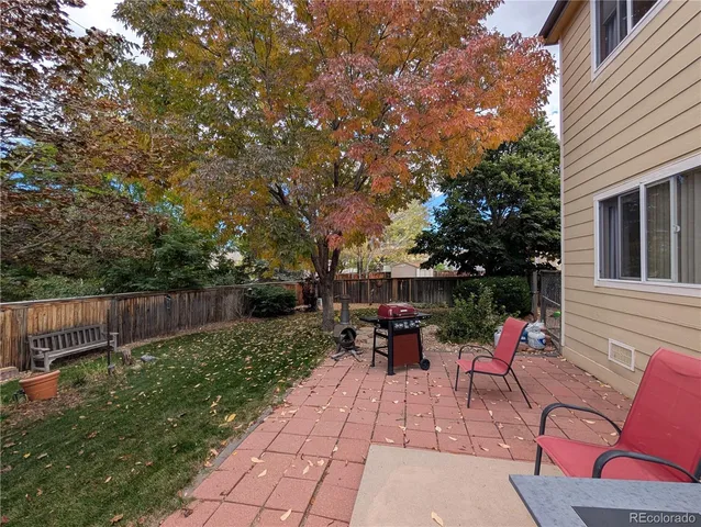 a backyard of a house with fountain table and chairs