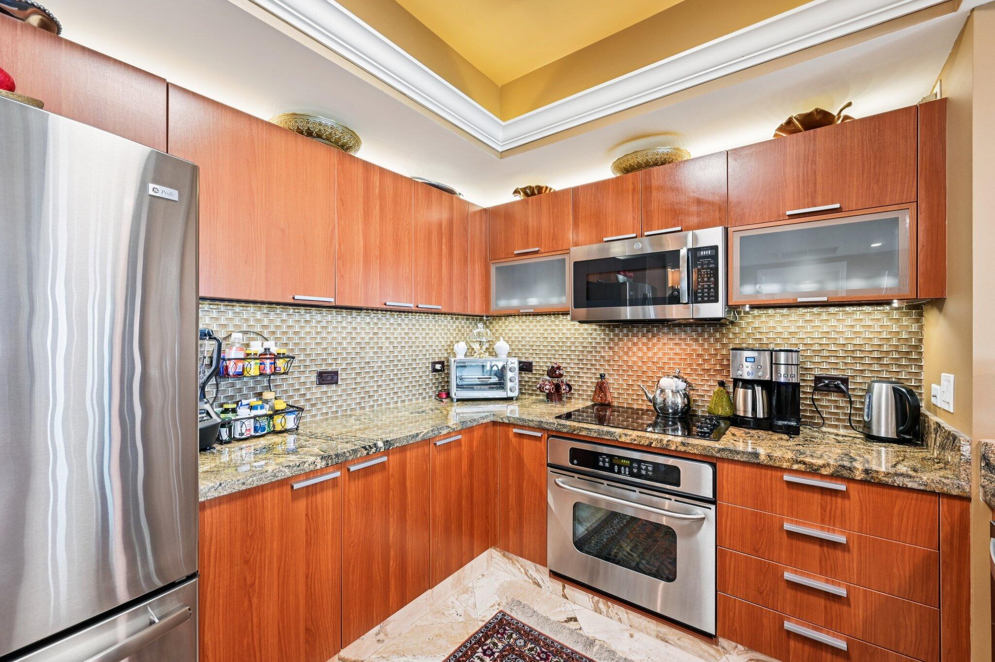 2640 Lake Shore Drive, Unit 1510 Riviera Beach, FL 33404 - Photo 19 of 52 a kitchen with stainless steel appliances a stove a sink and a refrigerator